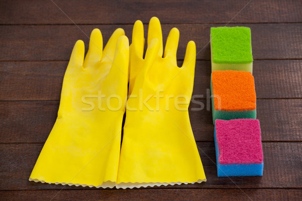 Glove and scrubber arranged on wooden floor Stock photo © wavebreak_media
