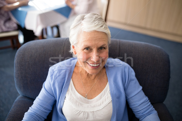 Stock photo: High angle view of smiling senior woman sitting on armchair