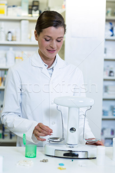 Pharmacist measuring tablets with pharmacy scale Stock photo © wavebreak_media