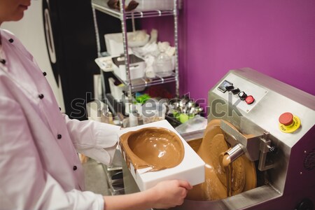 Stock photo: Worker filling mould with melted chocolate