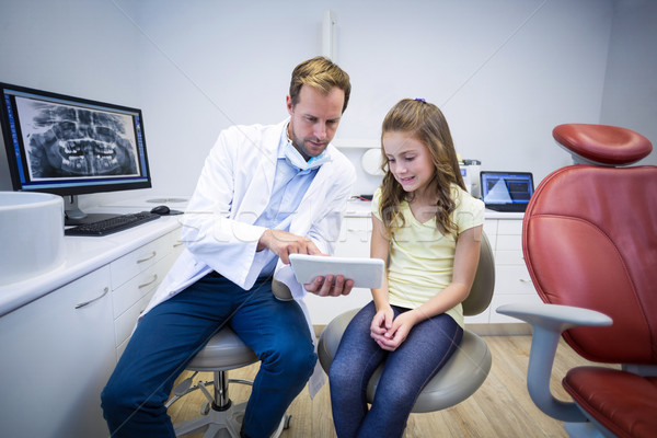 Stock photo: Dentist showing digital tablet to young patient