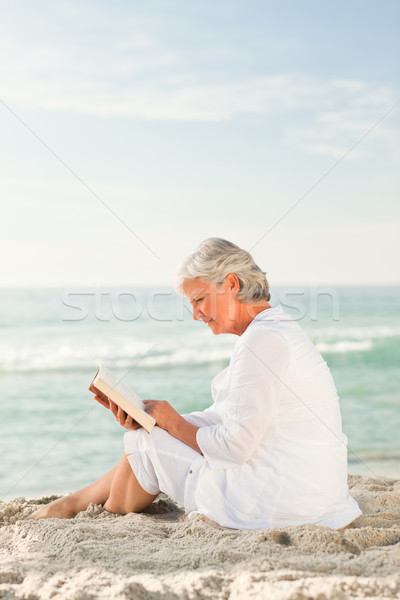 Idős nő olvas könyv tengerpart naplemente tenger Stock fotó © wavebreak_media