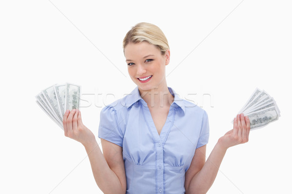 Smiling woman holding money in her hands against a white background Stock photo © wavebreak_media