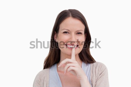 Close up of smiling woman asking for silence against a white background Stock photo © wavebreak_media