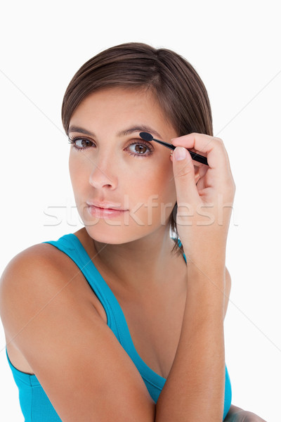 Attractive young woman putting eyeshadow on her eyelid Stock photo © wavebreak_media