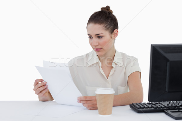 Stock photo: Focused businesswoman looking a document against a white background