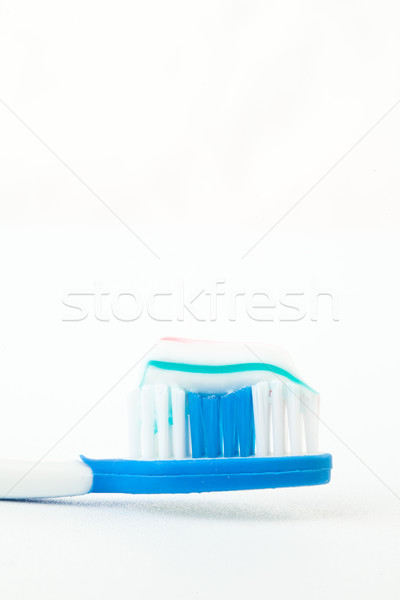 Toothpaste on a toothbrush against white background Stock photo © wavebreak_media