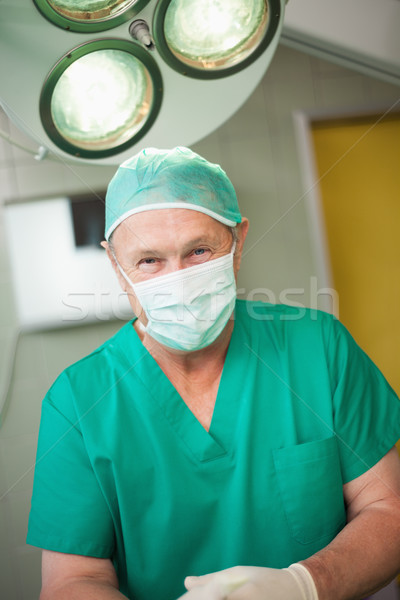 Surgeon smiles as he stands in a surgical room Stock photo © wavebreak_media