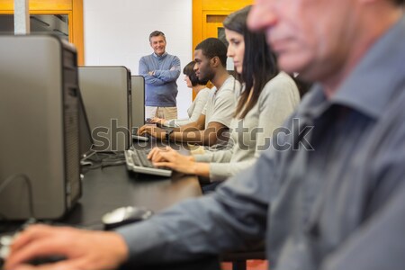 Teacher helping her students in computer class in college Stock photo © wavebreak_media