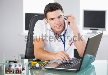 Portrait of smiling computer engineer on call in front of open c Stock photo © wavebreak_media