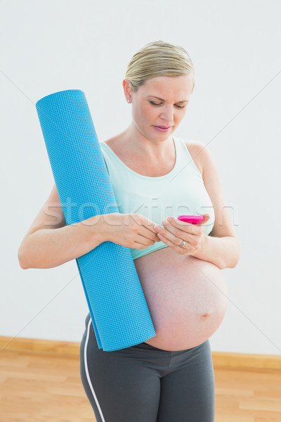 Terhes nő tart testmozgás küldés szöveges üzenet fitnessz Stock fotó © wavebreak_media