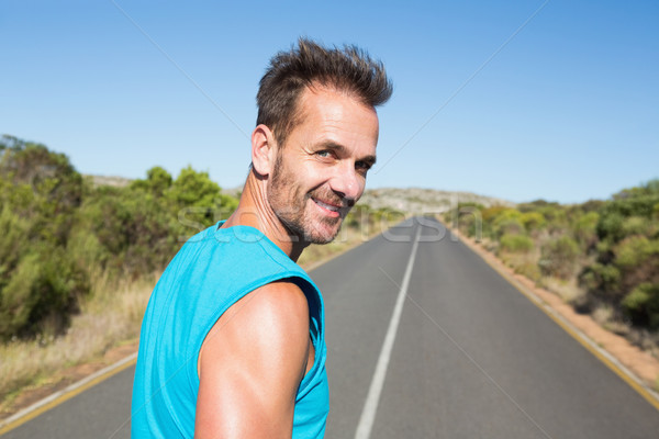 Fit man jogging on the open road smiling at camera Stock photo © wavebreak_media