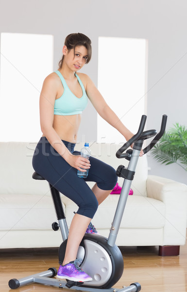 Stock photo: Fit brunette working out on exercise bike