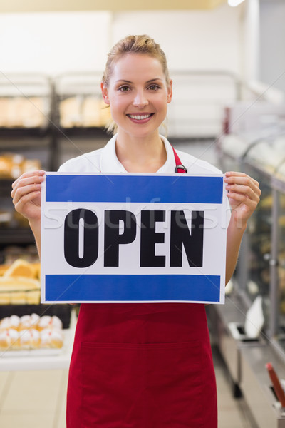 Stock photo: Portrait of a smiling blonde woman holding a sign