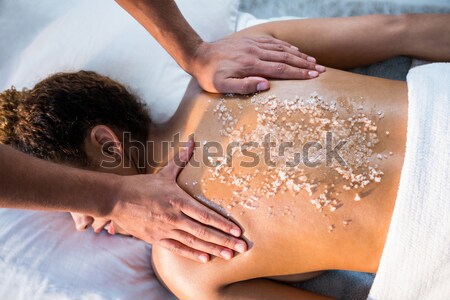 Stock photo: Woman receiving a salt scrub massage