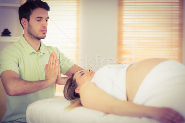 Relaxed pregnant woman getting reiki treatment Stock photo © wavebreak_media