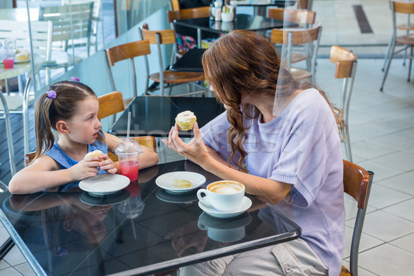 Stock photo: Mother and daughter enjoying cakes