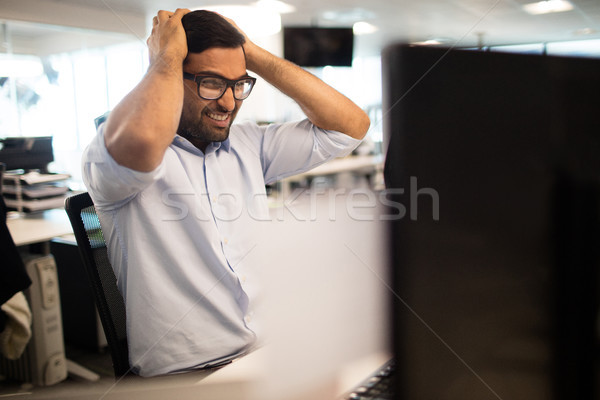 Tensed businessman clenching teeth in office Stock photo © wavebreak_media