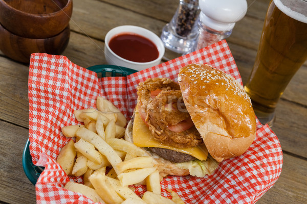 Hamburger sültkrumpli fonott kosár fa asztal sör Stock fotó © wavebreak_media