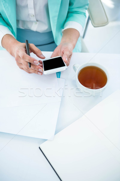 Businesswoman using her smart phone Stock photo © wavebreak_media