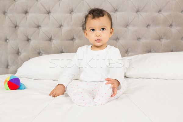 Cute bebé sesión cama mirando alrededor Foto stock © wavebreak_media