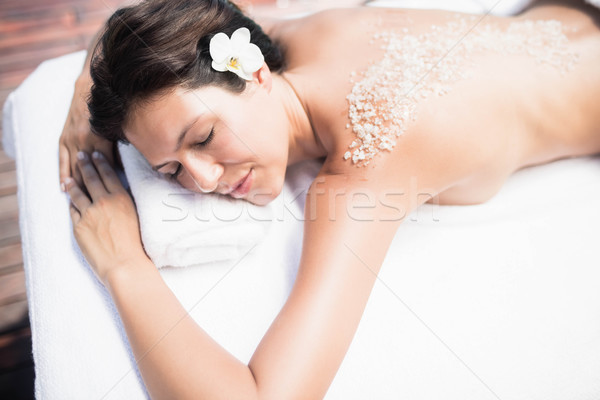 Stock photo: Woman lying on massage table with salt scrub on back 