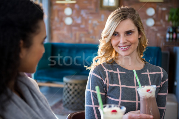 Female friends interacting with each other while having coffee Stock photo © wavebreak_media