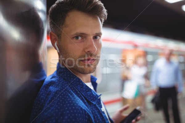 Portrait bel homme écouter chanson téléphone portable chemin de fer [[stock_photo]] © wavebreak_media