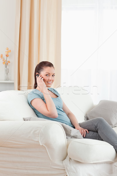 Dobrze wygląda telefonu kobieta posiedzenia sofa salon moda Zdjęcia stock © wavebreak_media