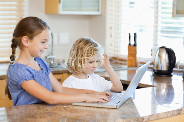 Siblings together on the laptop in the kitchen Stock photo © wavebreak_media