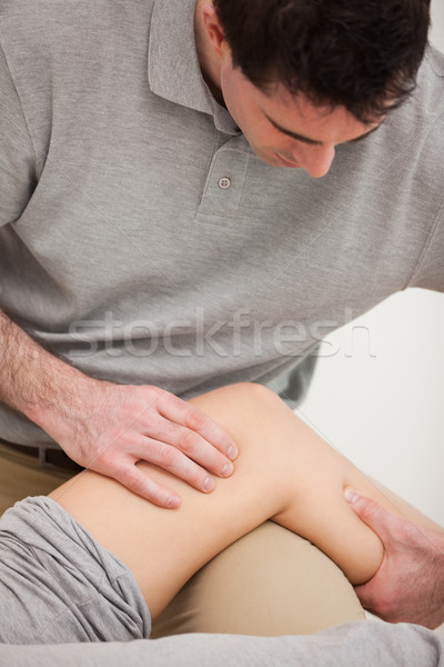 Physiotherapist looking at the knee of his patient indoors Stock photo © wavebreak_media