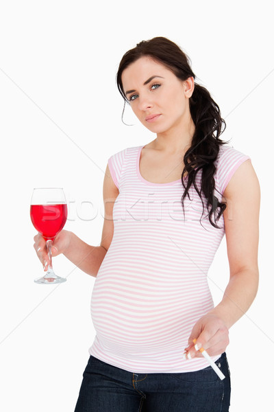 Gravidă bruneta bauturi alcoolice ţigară alb Imagine de stoc © wavebreak_media