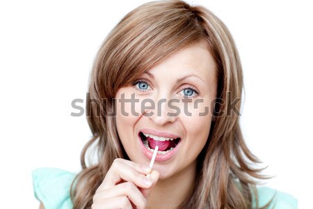 Happy blonde woman biting a chili against a white background Stock photo © wavebreak_media