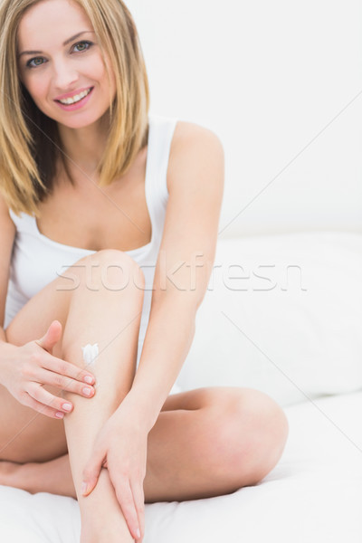 Kobieta krem nogi posiedzenia bed Zdjęcia stock © wavebreak_media
