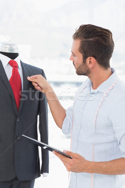 Fashion designer with digital tablet looking at suit on dummy Stock photo © wavebreak_media