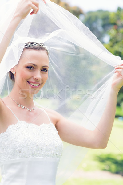Happy beautiful bride unveiling self in garden Stock photo © wavebreak_media