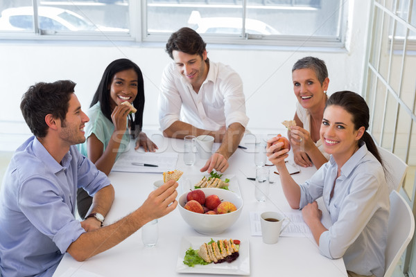 Trabalhadores rir alimentação sanduíches almoço escritório Foto stock © wavebreak_media