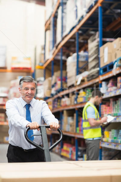 Manager pulling trolley with boxes in front of his employee Stock photo © wavebreak_media