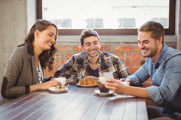 Mosolyog barátok néz okostelefon kávéház étel Stock fotó © wavebreak_media