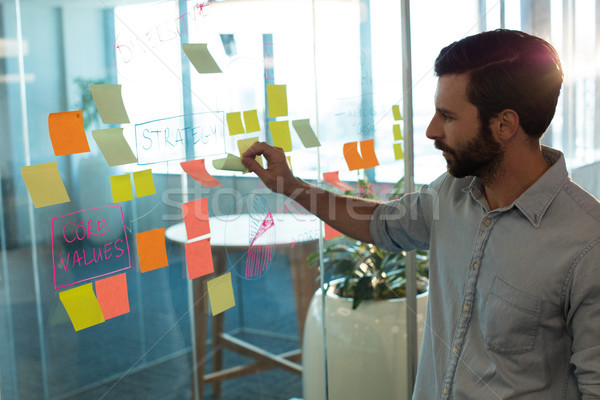 Businessman analyzing adhesive notes on glass Stock photo © wavebreak_media