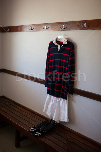 Rugby uniform hanging over shoes in locker room Stock photo © wavebreak_media