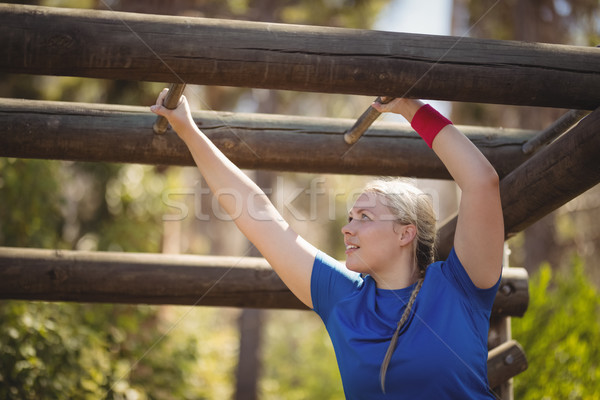 Determined woman exercising on monkey bar during obstacle course Stock photo © wavebreak_media