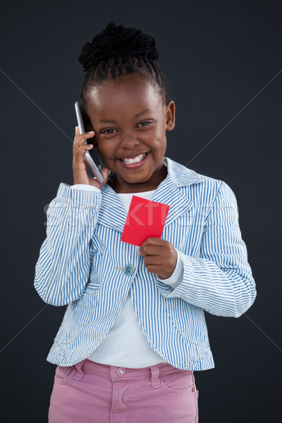 Portrait of cheerful businesswoman talking on phone while holding red card Stock photo © wavebreak_media