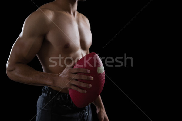 Muscular American football player holding a football in his hand Stock photo © wavebreak_media