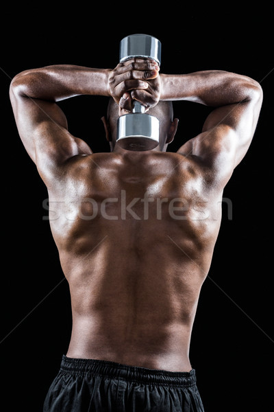 Rear view of muscular man lifting dumbbell Stock photo © wavebreak_media