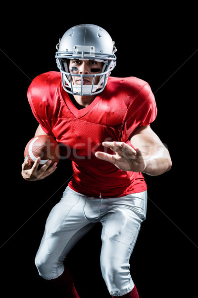 Portrait of defensive sportsman holding American football Stock photo © wavebreak_media