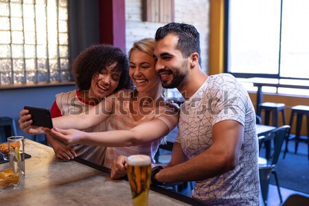 Friends using mobile phone in bar Stock photo © wavebreak_media