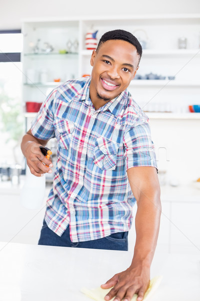 Smiling man cleaning kitchen counter Stock photo © wavebreak_media
