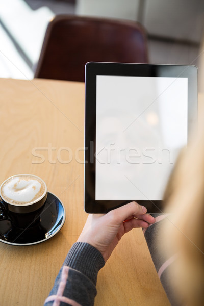 Woman using digital tablet with cup of coffee on table Stock photo © wavebreak_media