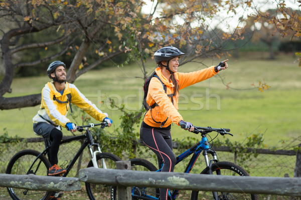 Biker couple cycling and pointing in distance Stock photo © wavebreak_media